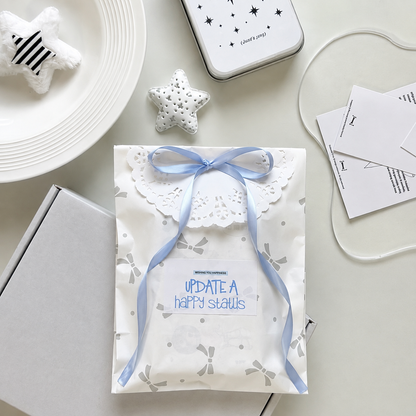 White gift box with blue ribbon and packaging accessories
